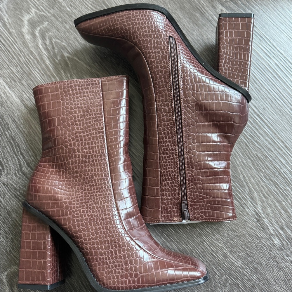 White ankle croc style boots with black trim and zipper